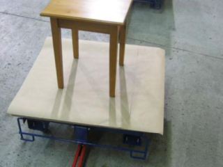 Towline system with rotating carts used to convey these awkward shaped furniture pieces through assembly and finishing.