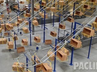 Box conveyor system for large distribution center. Delivers empty cartons from carton erector to packing areas.
