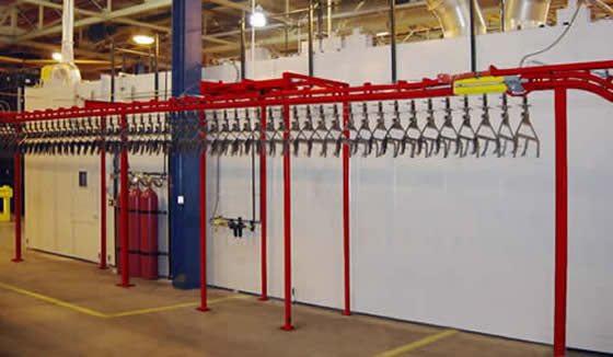 Power and free conveyor accumulates carriers for the curing oven.