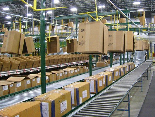 Overhead conveyors deliver empty cartons to order pickers in distribution centers