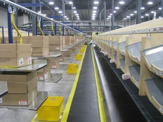 Carton conveyor delivery to sortation chutes in distribution center.