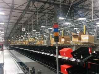Conveyor system for empty tote delivery nd corrugated carton removal in warehouse.