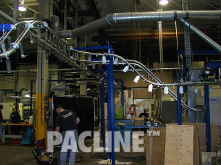 Enclosed track overhead conveyor designed to transfer machined auto parts through wash system.