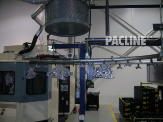 Enclosed track overhead conveyor transfers machined auto parts through wash and over dry off.