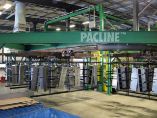 Custom trolleys designed for transferring steel panels through chemical wash on I beam conveyor system.