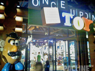 Toys placed on an overhead conveyor in a creative window display.