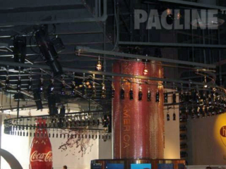 Hundreds of bottles of Coca Cola are carried overhead on a continuously moving PAC-LINE™ overhead conveyor.