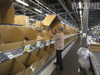 Cartons being delivered to order pickers on empty box overhead conveyor system.