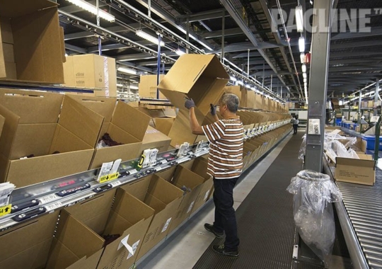 Cartons being delivered to order pickers on empty box overhead conveyor system.