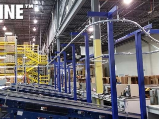 Empty box overhead conveyor integrated with equipment.