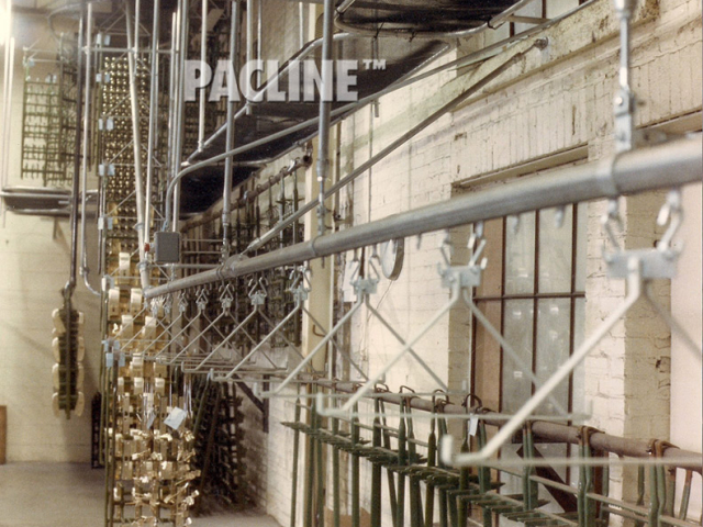 Overhead conveyor carries large racks of metal items through the electroplating process.