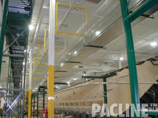 PACLINE overhead conveyor system with mesh basket guarding conveys empty carton delivery to automatic sorter packing stations.