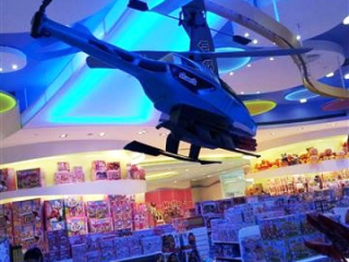 An overhead conveyor carries a Helicopter above store patrons in a Macau toy store.