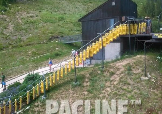 Alpine sleds being conveyed uphill by The PAC-LINE™ enclosed track overhead conveyor to waiting patrons.
