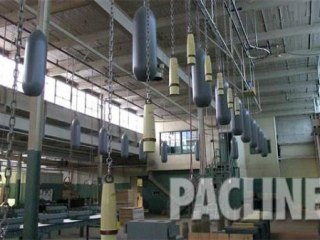 Enclosed track overhead conveyor carries munitions in a factory on the Bomb Girls movie set.