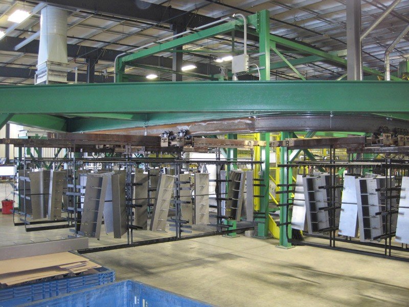 I-beam conveyor transports heavy racks through a cleaning process.