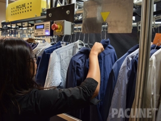 Loading garments on automated uniform distribution conveyor.