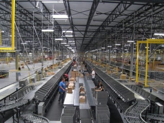 Pacline overhead conveyors deliver empty carton andempty totes in large distribution center.