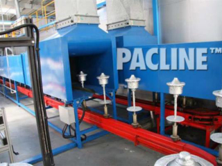 A PAC-MAX conveyor with a slot-side configuration, conveys product through the stages of a powder coating finishing