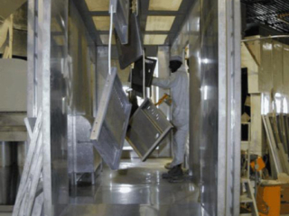 PACLINE&#039;s enclosed track overhead conveyor carries storage locker parts through powder coating finishing line.