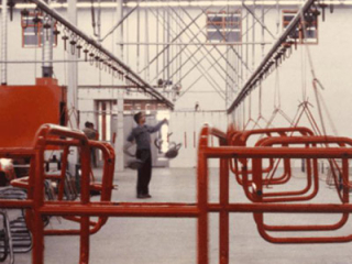 Powder finishing of chairs and stools using the PAC-LINE™ conveyor. Conveyor is ceiling supported.