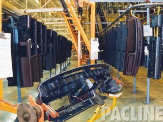 Buffer storage of automotive instrument panels at ceiling, guarded area, feeding overhead I-beam assembly conveyor.