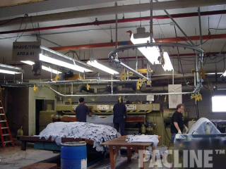 Leather hides transported between work stations using automatic release gravity clamps. The PAC-LINE overhead conveyor.