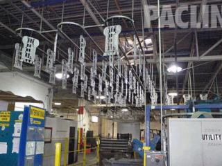 Aluminum auto parts are stored in overhead space during the cooling process using PACLINE&#039;s enclosed track conveyor.