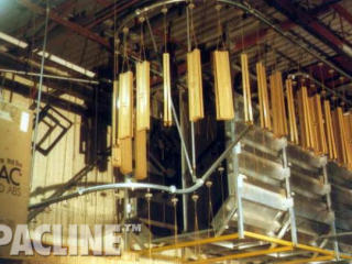 Overhead conveyor system designed to conserve floor space by utilizing ceiling space for storage between processes.
