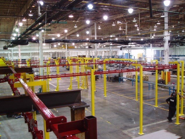 Power and free compact conveyor system for treatment of parts