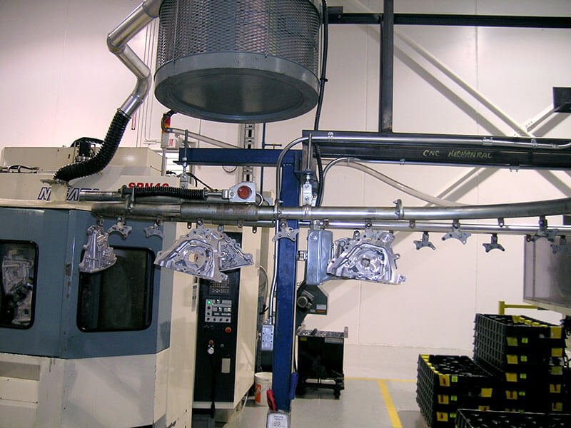 Compact overhead conveyor system to carry metal parts through a chemical wash.