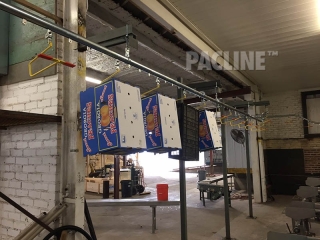 Hanging cartons on conveyor in packing shed.