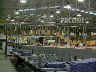 Apple packing house uses conveyor to transport empty cartons.