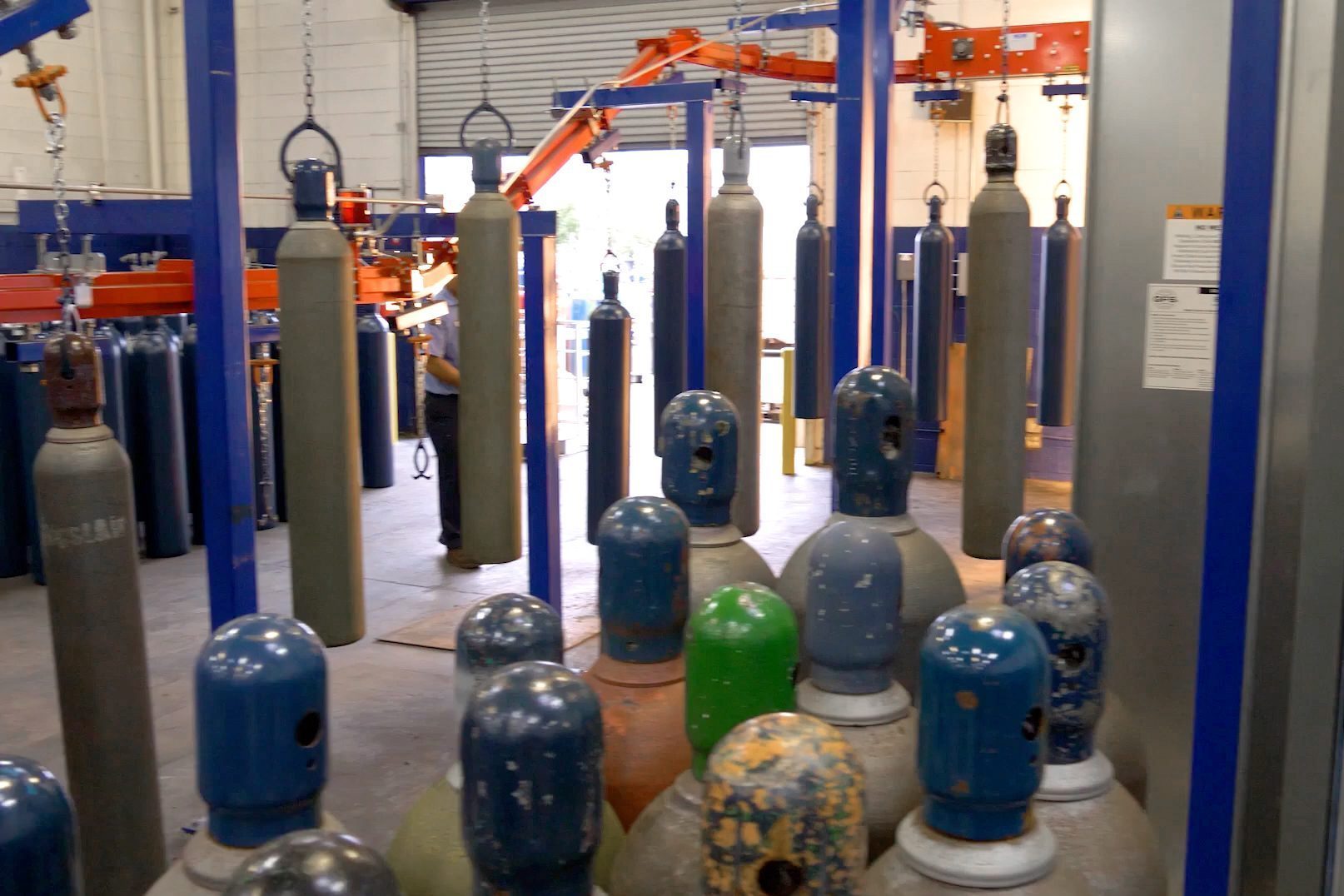 High capacity enclosed track conveyor for gas tank finishing lines