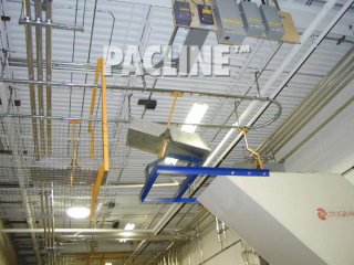 PACLINE&#039;s overhead conveyor removes plastic scrap and dumps waste into grinder for recycling.