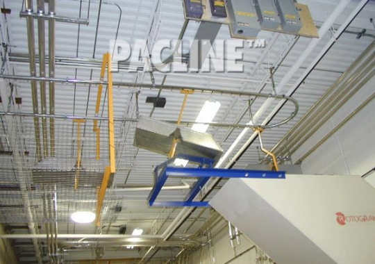 PACLINE&#039;s overhead conveyor removes plastic scrap and dumps waste into grinder for recycling.