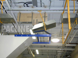Plastic scrap removal using The PAC-LINE overhead conveyor, dumping waste into grinder for recycling.