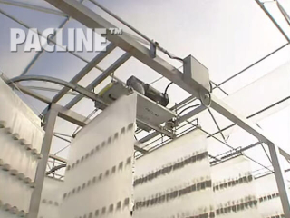 Enclosed track conveyor handles plants for indoor crop growing in this vertical farming greenhouse facility.