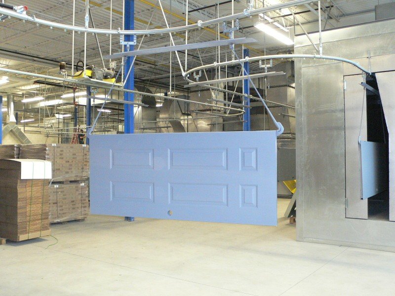Enclosed track overhead conveyor for wet spray painting line.