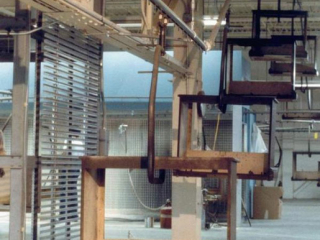 An overhead conveyor can handle steep inclines to move these frames up off the floor between finishing processes.
