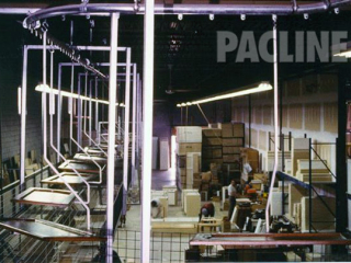 Overhead conveyor transports kitchen cabinet doors from manufacturing through the finishing process.