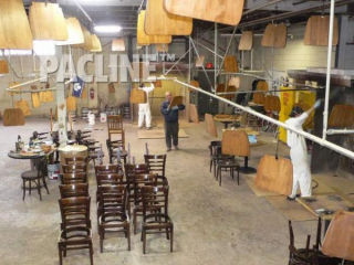 Overhead conveyor system designed to move wooden chair parts through complete finishing process.